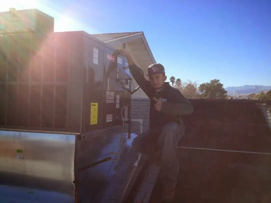 HVAC technician performing AC Tune-Up on a rooftop unit in Elma